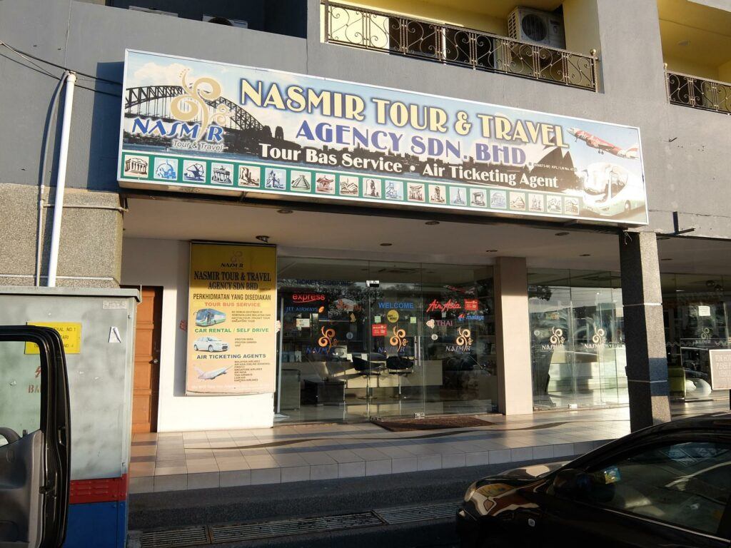 a large sign on the side of a building - File:Nasmir Tour and Travel Agency.jpg