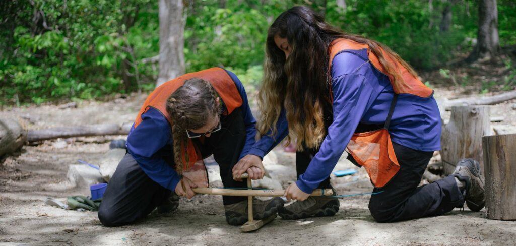 two people are standing in the woods - File:Survival Skills and Wilderness Therapy.jpg