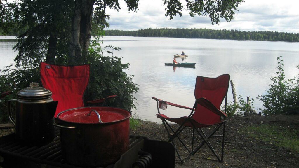 File:Camp scene.jpg - a red chair and a red chair in a field