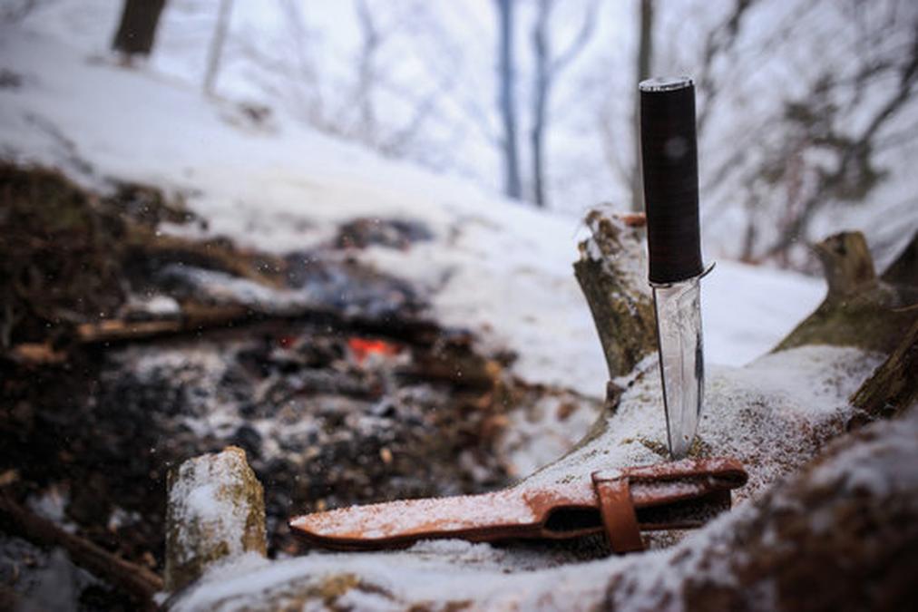 winter survival in the wild with knife - a knife stuck to a tree branch